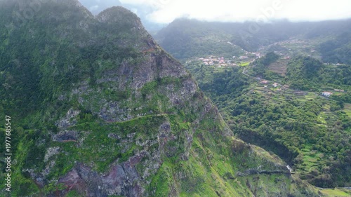 Breathtaking aerial view of Madeira's rugged north coast, showcasing lush green cliffs, terraced villages, and the deep blue Atlantic. A hiker's paradise. Boaventura