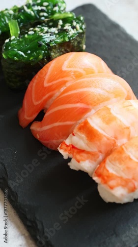 Savoring delicate salmon sushi nestled beside vibrant seaweed in a festive setting