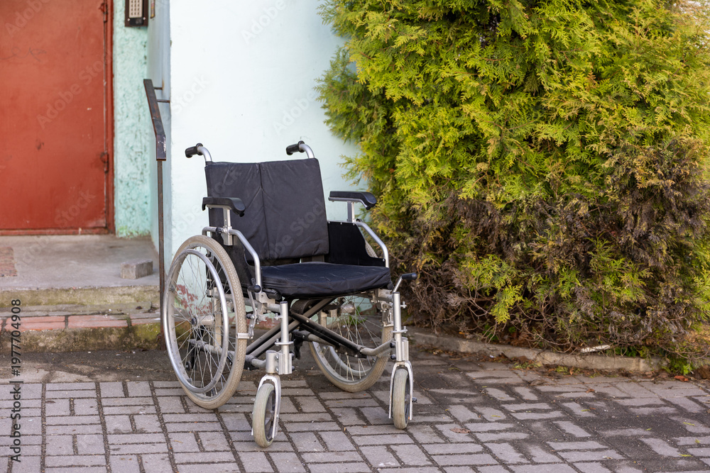 Obraz premium Wheelchair near building entrance with steps in outdoor setting