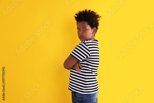 Принти на полотні Portrait of resentful little boy with crossed arms on yellow background