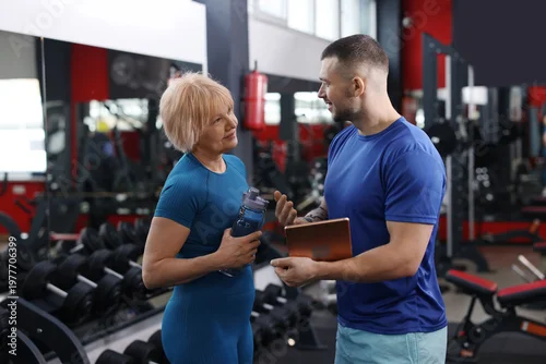 Panel kuchenny z motywem Senior woman with professional trainer in gym