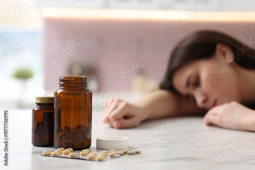 Fotografie Depressed woman with antidepressant pills at white marble table in kitchen, sele