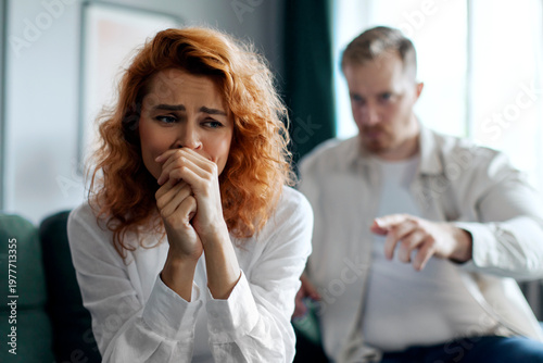 Obraz na płótnie Angry emotional man shouting at his depressed crying wife, couple having quarrel at home
