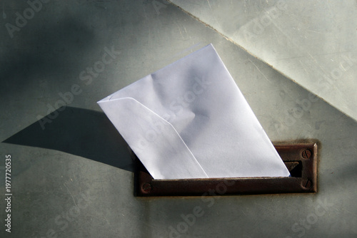 An envelope placed in retro styled mailbox with patina