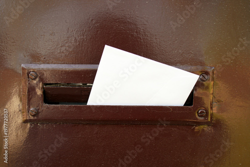 An envelope placed in retro styled mailbox with patina