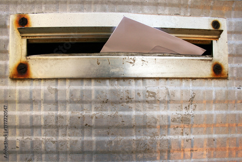 An envelope placed in retro styled mailbox with patina