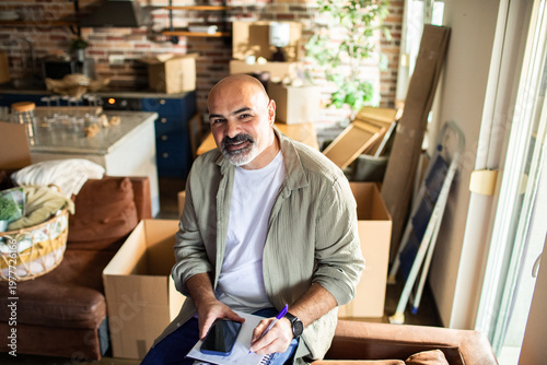 Smiling man planning home move in living room
