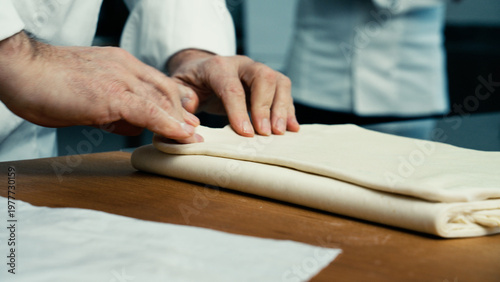 pastry chef hands folding puff pastry