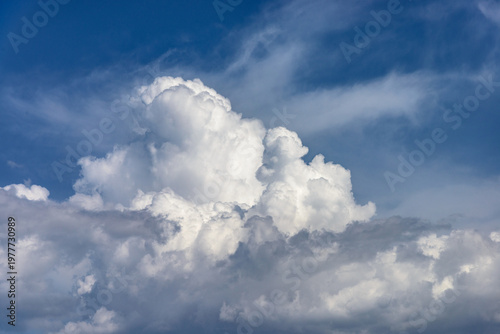 Cumulus white clouds bofies towering in clear blue sky background.