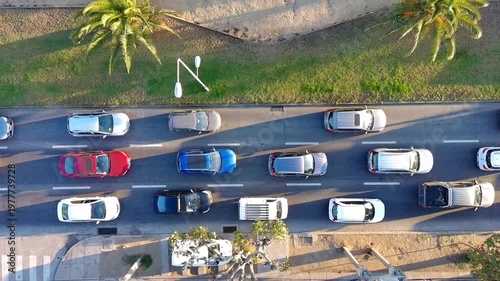 Traffic congestion on a busy urban road with multiple cars moving slowly. Ideal for concepts related to traffic jams, commuting, transportation problems, urban mobility, pollution, rush hour, and city