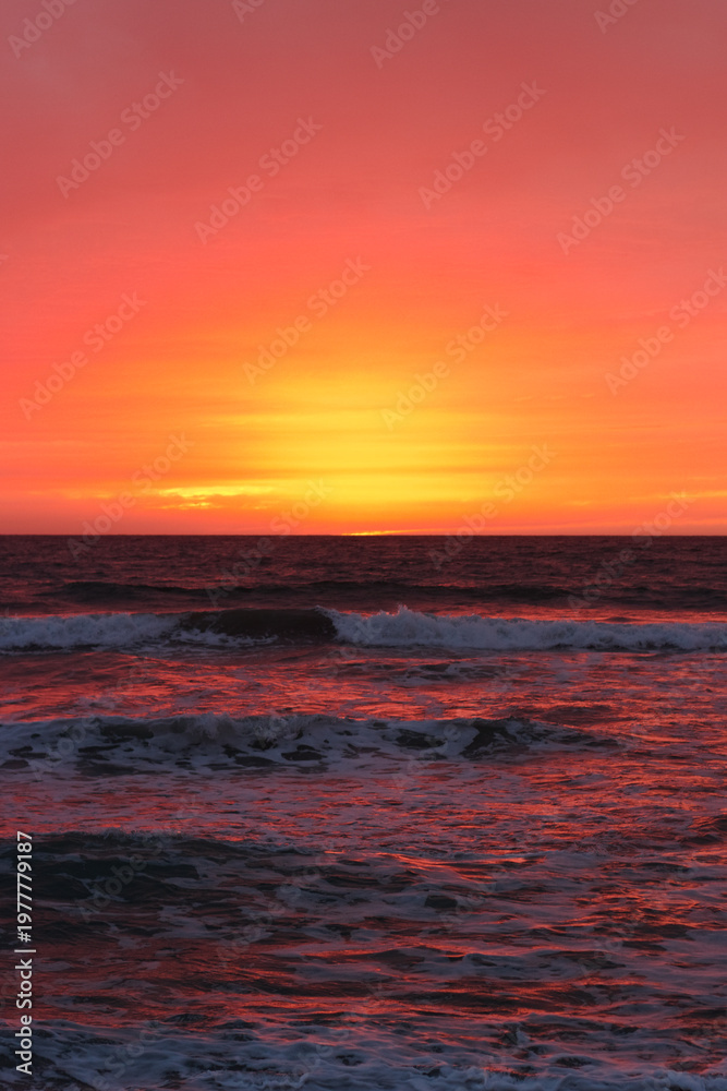 Obraz premium Vibrant Pacific Ocean Sunset Over Rolling Coastal Waves