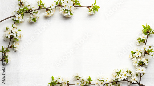 A vintage spring design featuring a frame of white snowdrops and green leaves on a weathered wooden background creates a natural floral border for a rustic greeting card