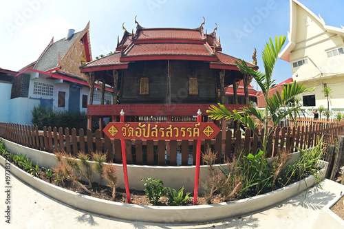 The scripture hall in the middle of the water at Wat Apsarasawan Worawihan is a traditional Thai-style wooden building designed to protect the Buddhist scriptures from ants and termites.