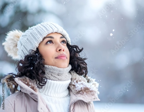 Young woman enjoying a snowy winter day, looking up with a serene expression.