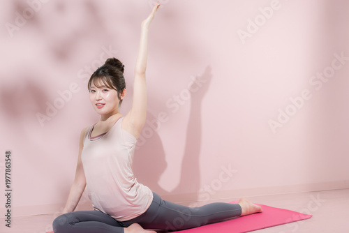 股関節の柔軟と体幹を鍛える女性のフィットネスとストレッチイメージ　ヨガや筋トレなどカメラ目線の全身