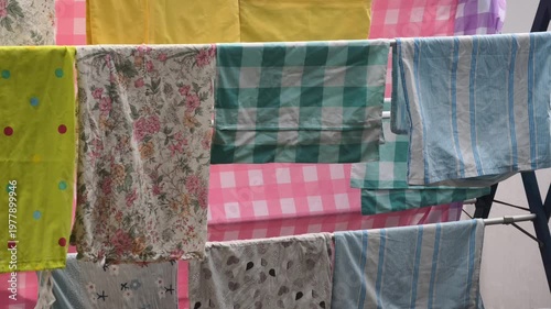 Assortment Of Colorful Textiles Drying On A Clothesline In Bright Sunlight With A Blue Sky Background