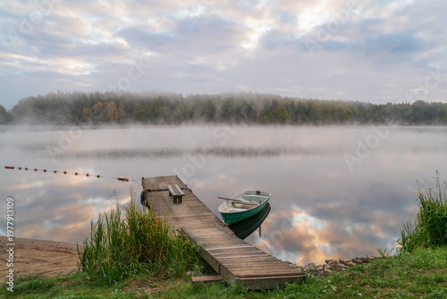 Rowing boat near the pier on the shore of Lake Ladoga near the village of Lumivaara on a foggy autumn morning, Ladoga Skerries National Park, Republic of Karelia, Russia