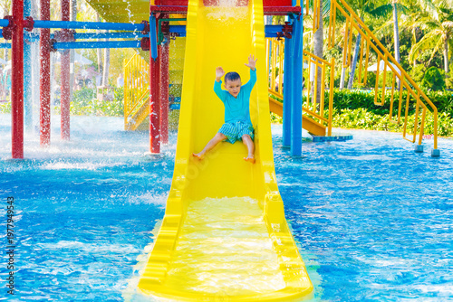 Photography Caucasian cute happy kid boy rides water slide in a water park in summer vacation