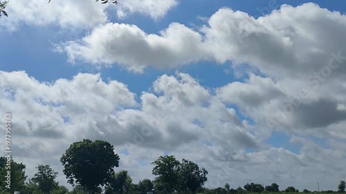 Fluffy White Clouds Moving Across Blue Sky With Green Trees For Nature Backgrounds