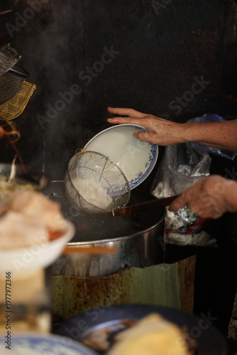 Картината върху платно Hand of street vendor blanching noodles in hot water, authentic Vietnamese food