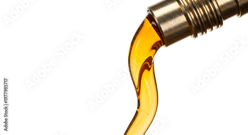 Golden liquid pouring from metal nozzle isolated on white background industrial lubricant or oil flow