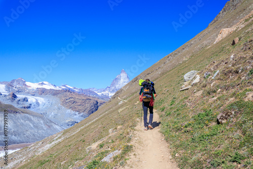 Mountain panorama with hiking mountaineer and Matterhorn in Pennine Alps, Switzerland