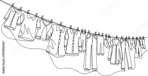 Laundry drying on a clothesline in the sun and wind with shirts socks and dresses hanging