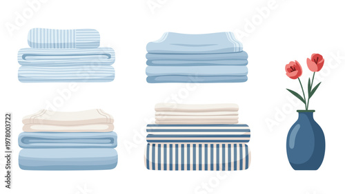 Neat stacks of folded blue and white towels and linens placed next to a simple blue vase holding two red tulips on a clean white surface.