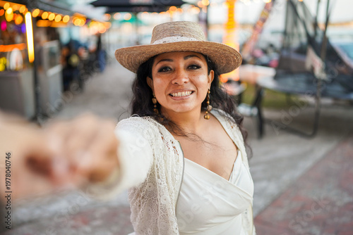 Latina woman smiling extending hand at market festival
