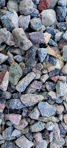 Close-up of colorful natural gravel stones forming a detailed textured background, perfect for wallpaper with a raw, earthy feel and subtle tones that create depth and visual interest.