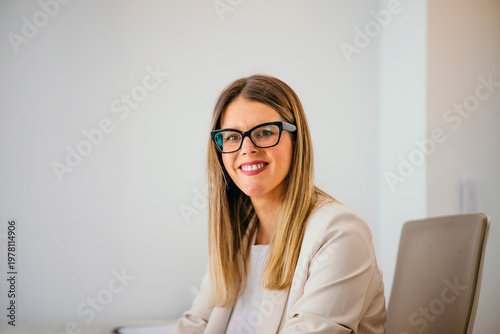 Professional woman wearing glasses smiling in office achieving success