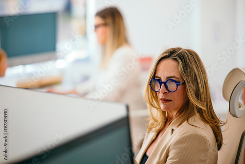 Woman working with blue glasses in open office