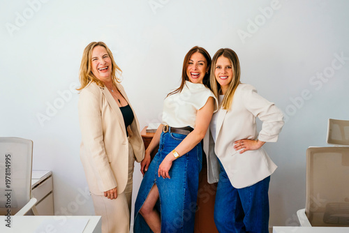 Cheerful businesswomen collaborating and embracing female empowerment