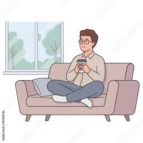 A man sits on a couch with a cup by a window.