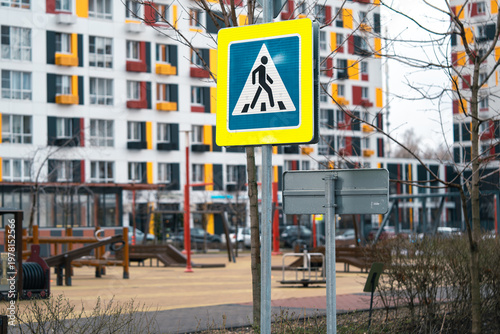  Playground and pedestrian crossing sign near colorful apartment buildings in a modern city setting. The vibrant environment emphasizes urban design and community living.