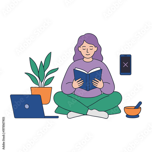 A woman sits cross-legged reading a book next to a laptop and potted plant.