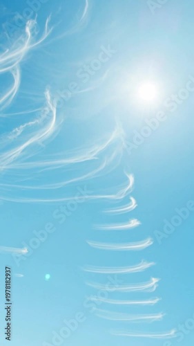 Wispy cirrus clouds drifting across a vibrant clear blue sky, soft atmospheric weather background.
