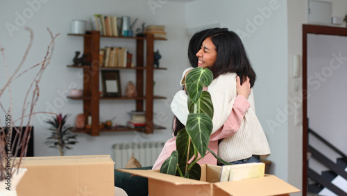Cuadro en lienzo Women friends hugging celebrating new home moving day