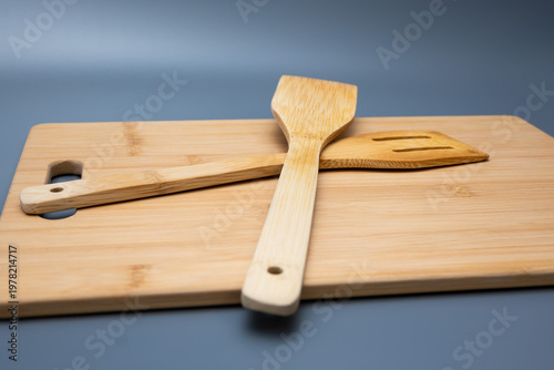 Spatulas on Bamboo Board Against Blue Gradient