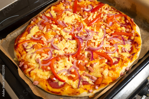 Ready Pizza with Cheese and Vegetables Taken Out of Oven in Mitt