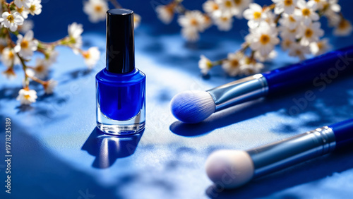 Blue nail polish bottle with brushes on floral surface