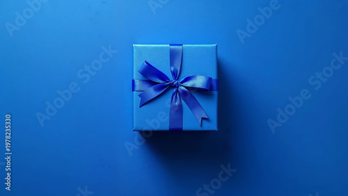 Blue gift box with ribbon on monochrome blue background