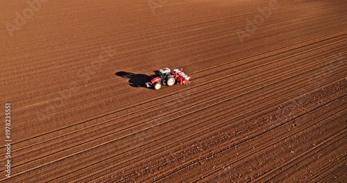Aerial drone view of a tractor sowing in a vast field