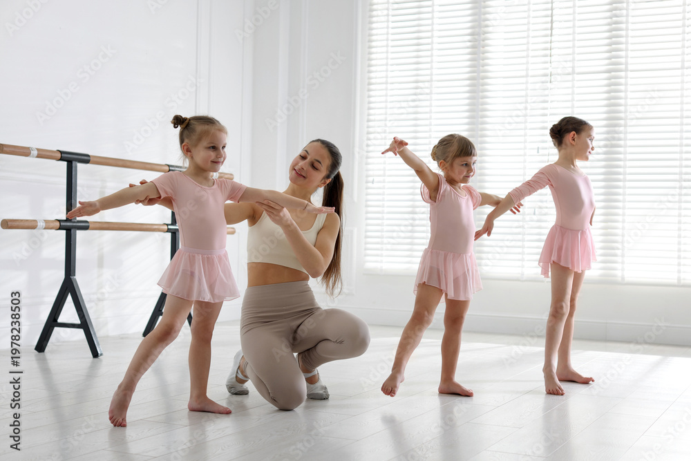Naklejka premium Ballet teacher having class with children in dance studio