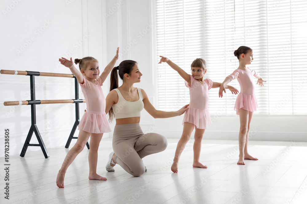 Obraz premium Ballet teacher having class with children in dance studio