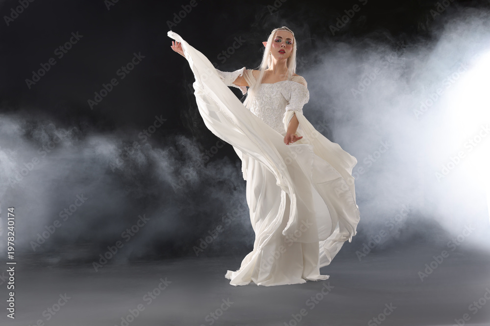 Naklejka premium Beautiful girl dressed as elf on black background with smoke