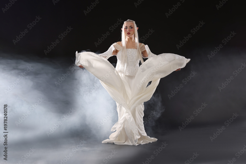 Naklejka premium Beautiful girl dressed as elf on black background with smoke