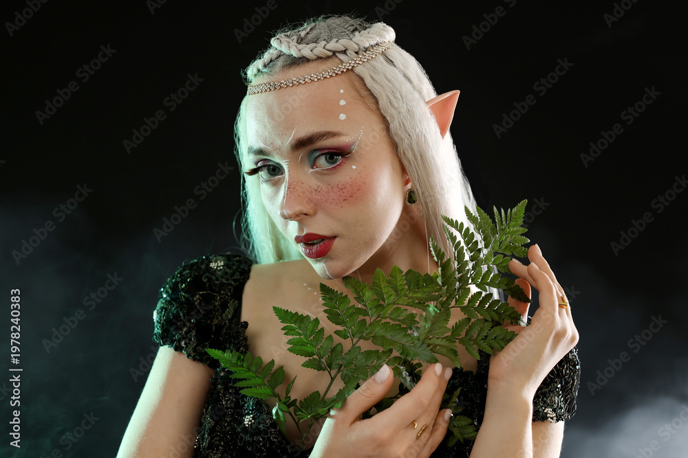 Naklejka premium Beautiful elf girl with floral decor on black background with smoke
