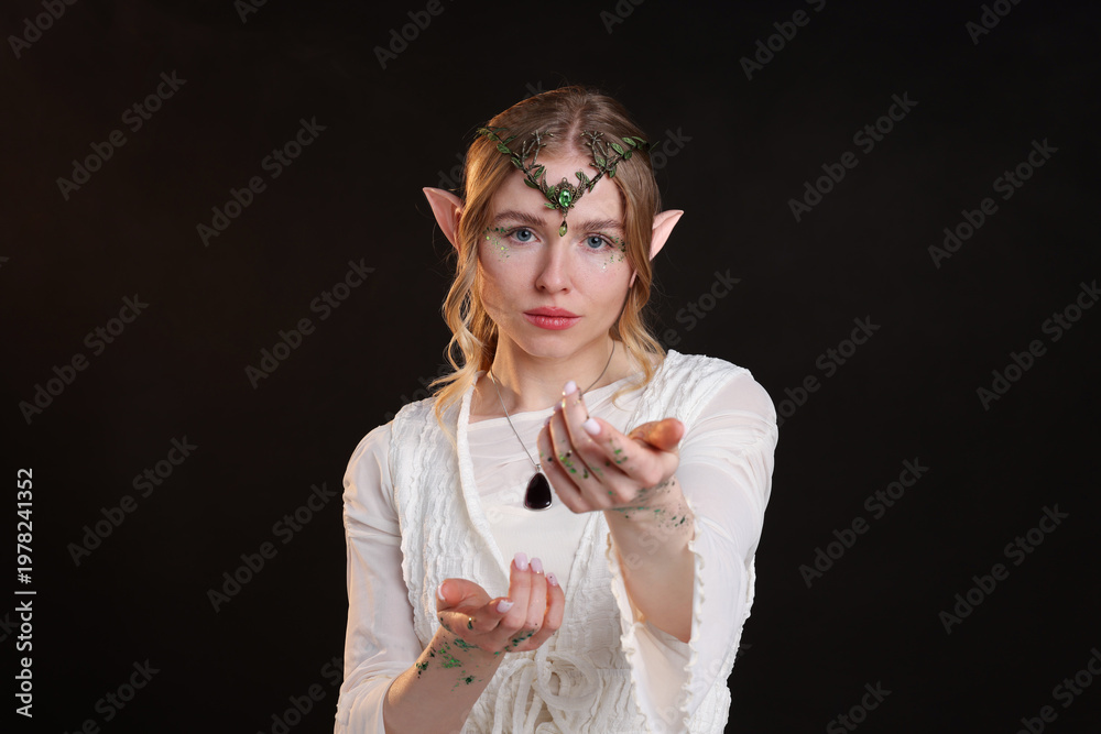 Naklejka premium Beautiful girl dressed as elf on dark background