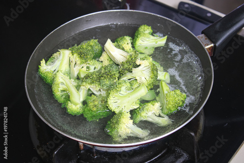 Картината върху платно Fresh Green Broccoli Florets Boiling In Pan Of Hot Water